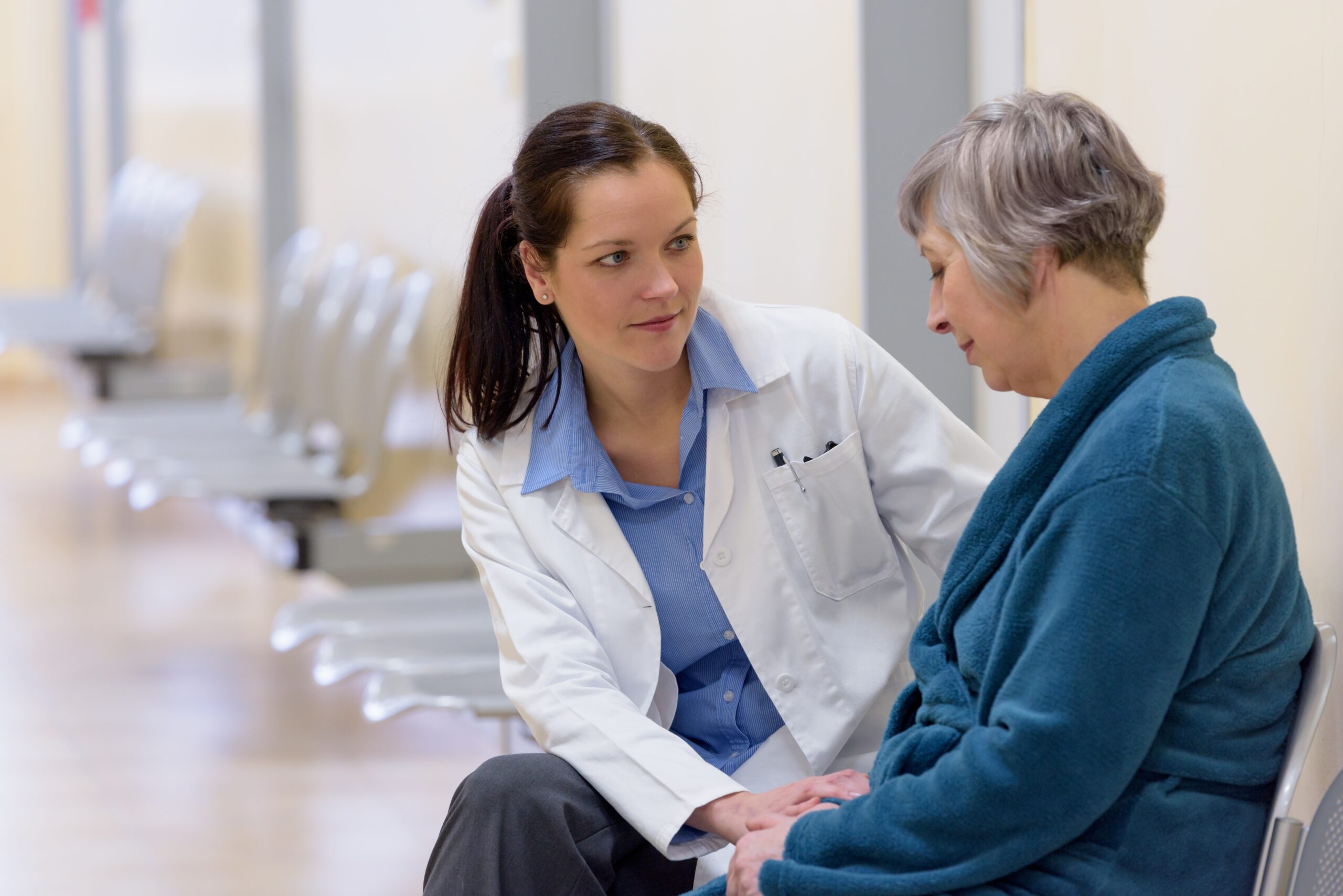 Female doctor comforting senior cancer patient in hospital