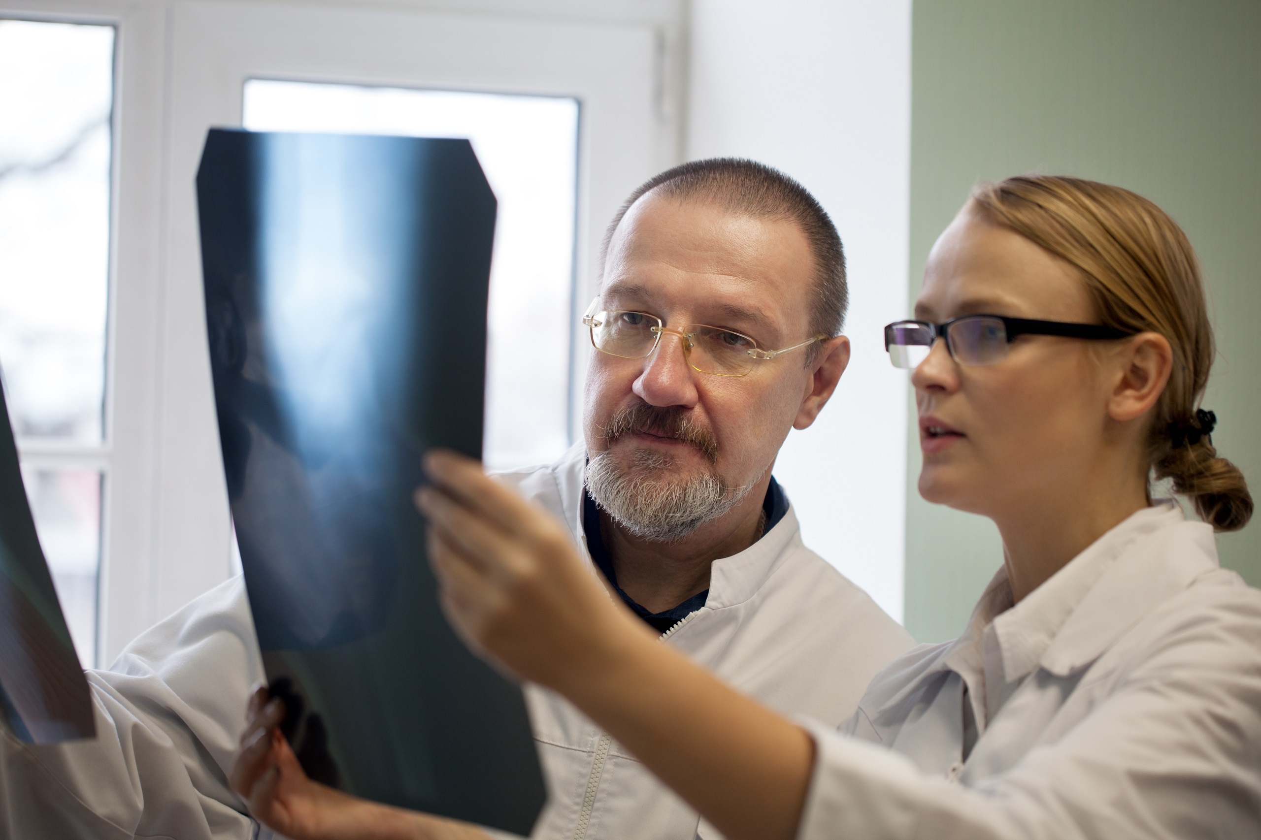 Senior and young doctors examining cancer x-ray images