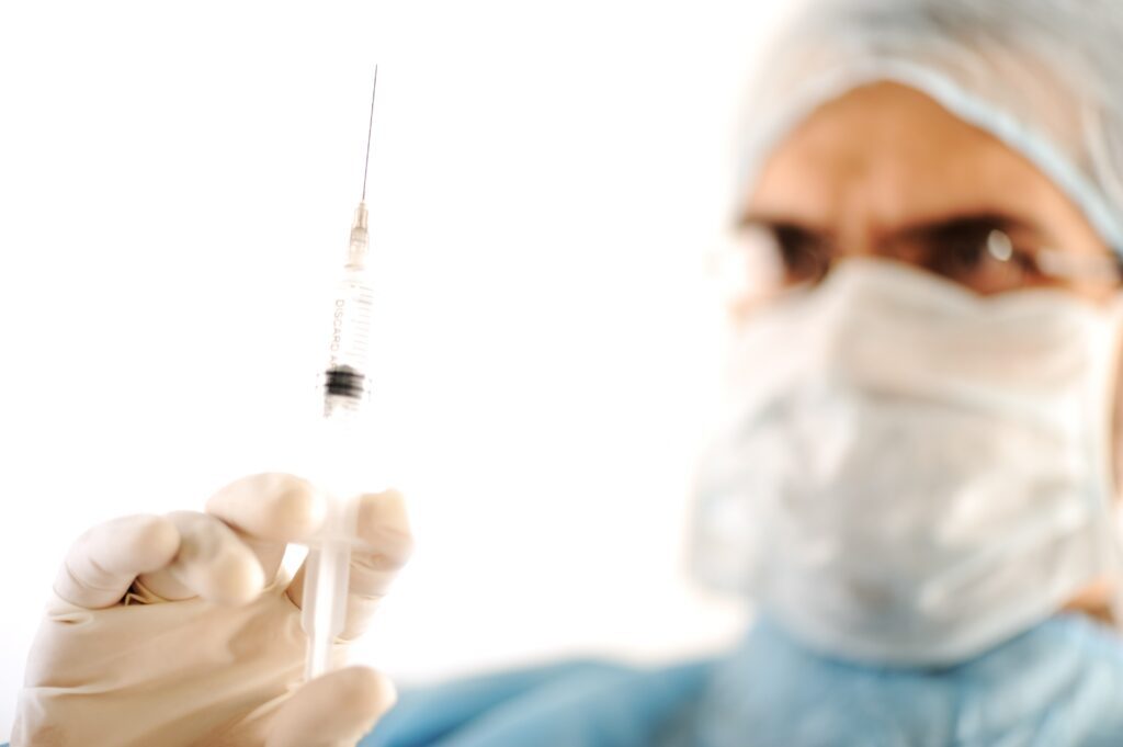 Surgeon holding injection treatment vaccine