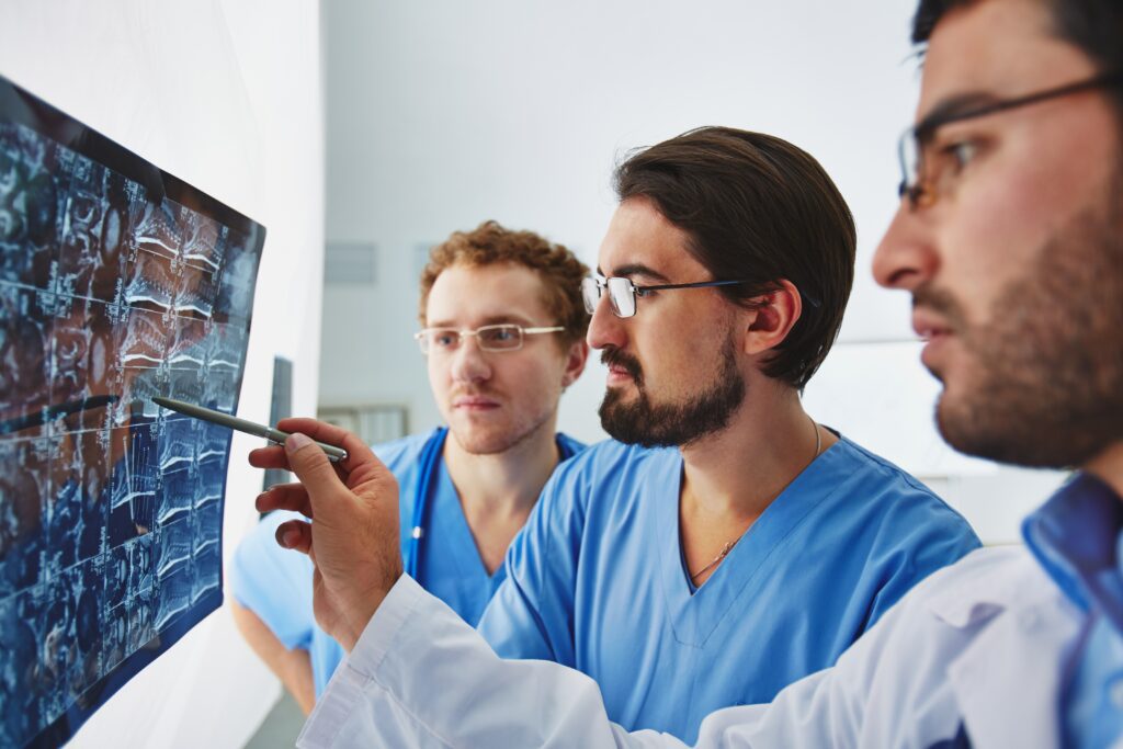 Young male doctors looking at tumor x-ray and analyzing it