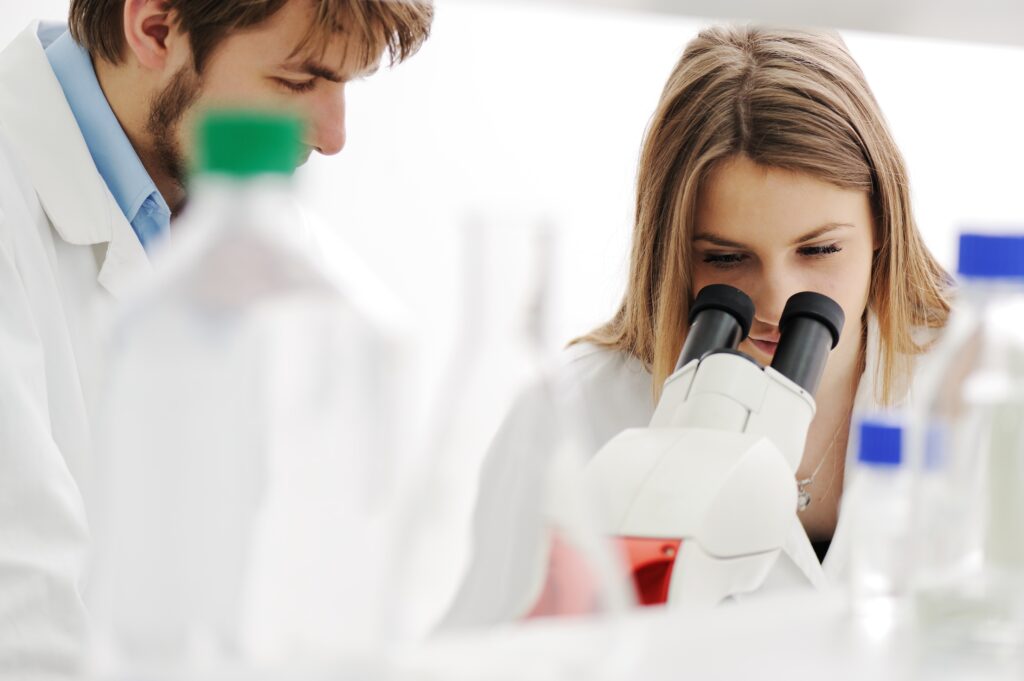 Young science workers research cancer cells at medical lab